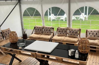 Table de tennis de table bleue en extérieur, avec deux raquettes rouges posées de part et d'autre du filet.