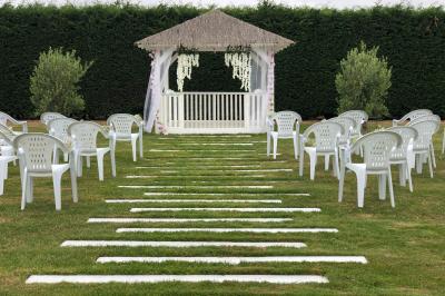 Table de tennis de table bleue en extérieur, avec deux raquettes rouges posées de part et d'autre du filet.