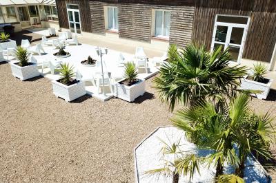 Table de tennis de table bleue en extérieur, avec deux raquettes rouges posées de part et d'autre du filet.