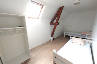 Table de tennis de table bleue en extérieur, avec deux raquettes rouges posées de part et d'autre du filet.