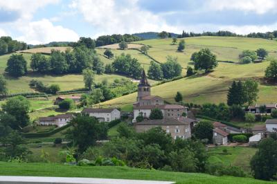 Salon lumineux avec canapé beige, table basse en bois, cuisine ouverte et séparation en bois devant un lit.