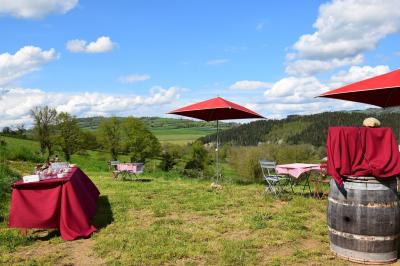 Salon lumineux avec canapé beige, table basse en bois, cuisine ouverte et séparation en bois devant un lit.