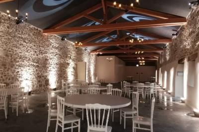 Salon lumineux avec canapé beige, table basse en bois, cuisine ouverte et séparation en bois devant un lit.