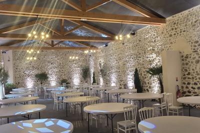 Salon lumineux avec canapé beige, table basse en bois, cuisine ouverte et séparation en bois devant un lit.