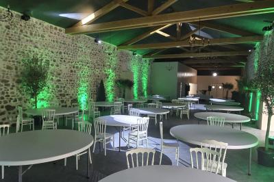 Salon lumineux avec canapé beige, table basse en bois, cuisine ouverte et séparation en bois devant un lit.