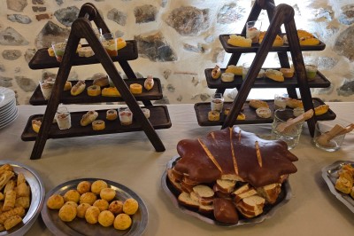 Village rural avec église au clocher pointu, entouré de collines verdoyantes et de prairies sous un ciel partiellement…