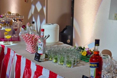 Village rural avec église au clocher pointu, entouré de collines verdoyantes et de prairies sous un ciel partiellement…