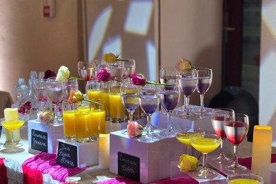 Village rural avec église au clocher pointu, entouré de collines verdoyantes et de prairies sous un ciel partiellement…