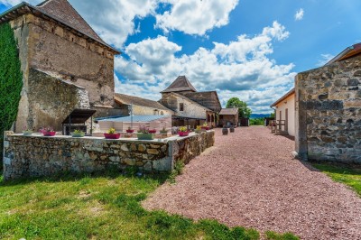 Buffet avec pâtisseries, viennoiseries, verrines et pains disposés sur des présentoirs en bois dans une salle.