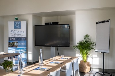 Assiette de brochettes de fruits de mer avec légumes, sauce colorée et riz, servie en extérieur sur une table dressée.