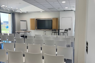 Assiette de brochettes de fruits de mer avec légumes, sauce colorée et riz, servie en extérieur sur une table dressée.