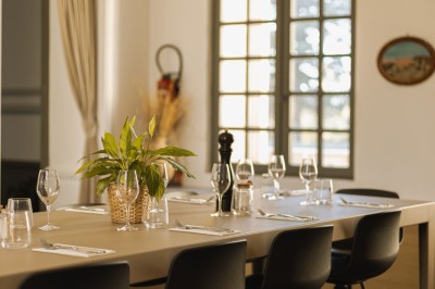 Assiette de brochettes de fruits de mer avec légumes, sauce colorée et riz, servie en extérieur sur une table dressée.
