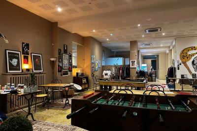 Assiette de charcuterie avec pain plat, cornichons, tapenade, fromage et beurre sur une table en bois.