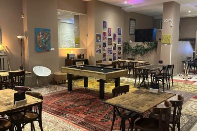 Assiette de charcuterie avec pain plat, cornichons, tapenade, fromage et beurre sur une table en bois.