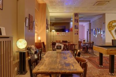 Assiette de charcuterie avec pain plat, cornichons, tapenade, fromage et beurre sur une table en bois.