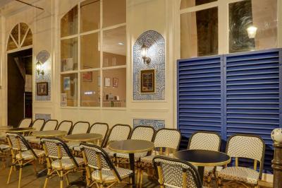 Assiette de charcuterie avec pain plat, cornichons, tapenade, fromage et beurre sur une table en bois.