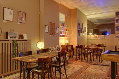 Assiette de charcuterie avec pain plat, cornichons, tapenade, fromage et beurre sur une table en bois.