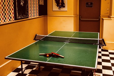 Assiette de charcuterie avec pain plat, cornichons, tapenade, fromage et beurre sur une table en bois.