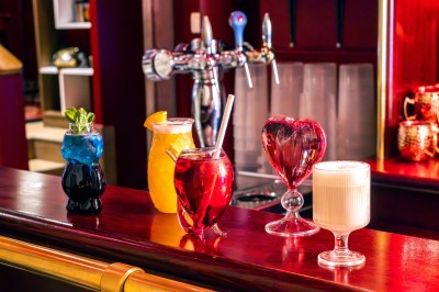 Assiette de charcuterie avec pain plat, cornichons, tapenade, fromage et beurre sur une table en bois.