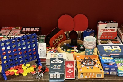 Assiette de charcuterie avec pain plat, cornichons, tapenade, fromage et beurre sur une table en bois.