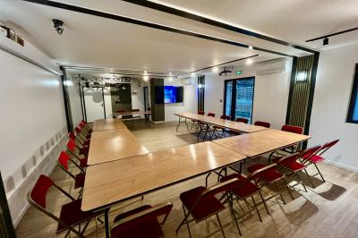 Entrée d'un immeuble avec porte vitrée, numéro 16 et inscription ’Bureaux’, sol pavé avec quelques feuilles.