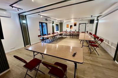 Entrée d'un immeuble avec porte vitrée, numéro 16 et inscription ’Bureaux’, sol pavé avec quelques feuilles.