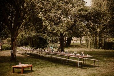 Chambre mansardée avec lit double, serviettes pliées, cygne en serviette, fauteuil et lumière naturelle.