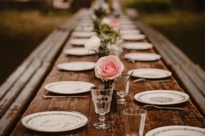 Chambre mansardée avec lit double, serviettes pliées, cygne en serviette, fauteuil et lumière naturelle.
