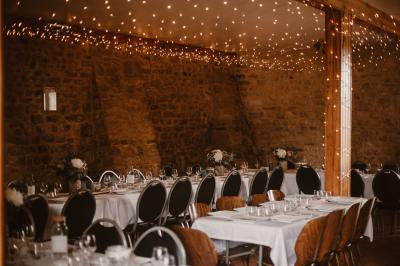 Chambre mansardée avec lit double, serviettes pliées, cygne en serviette, fauteuil et lumière naturelle.