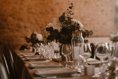 Chambre mansardée avec lit double, serviettes pliées, cygne en serviette, fauteuil et lumière naturelle.