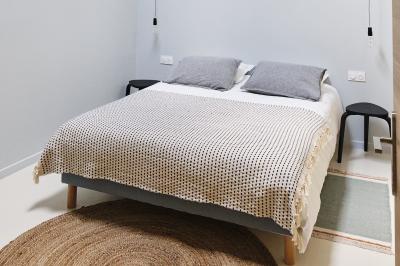 Table décorée avec des bougies, fleurs et sets en osier, entourée de coussins, bancs et éléments rustiques en bois.