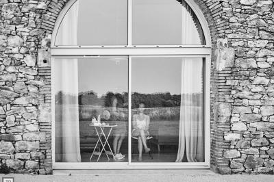 Table décorée avec des bougies, fleurs et sets en osier, entourée de coussins, bancs et éléments rustiques en bois.