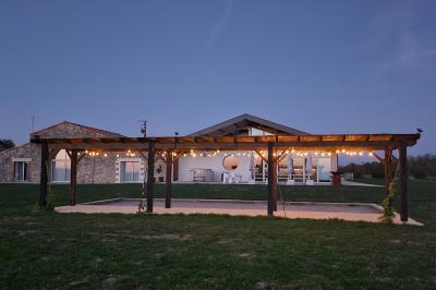 Table décorée avec des bougies, fleurs et sets en osier, entourée de coussins, bancs et éléments rustiques en bois.