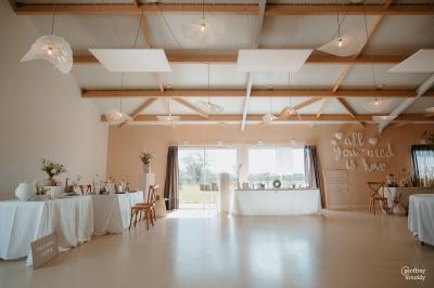 Des personnes participent à un atelier créatif dans une salle lumineuse, entourées de tables et de matériel artistique.
