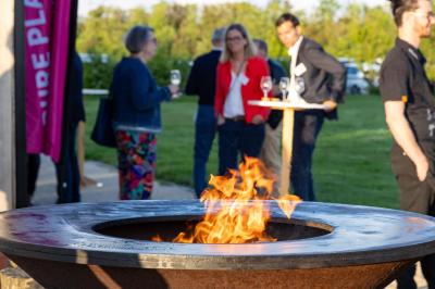Des personnes participent à un atelier créatif dans une salle lumineuse, entourées de tables et de matériel artistique.