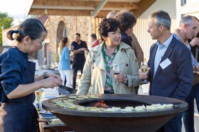 Des personnes participent à un atelier créatif dans une salle lumineuse, entourées de tables et de matériel artistique.