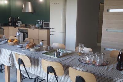 Des personnes participent à un atelier créatif dans une salle lumineuse, entourées de tables et de matériel artistique.