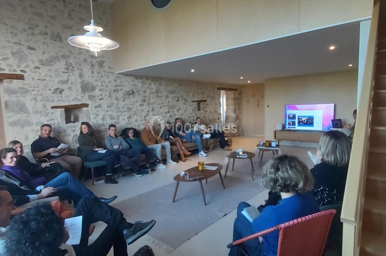Un groupe de personnes assises dans une salle en pierre, regardant une présentation sur un écran.