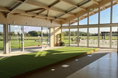 Des personnes participent à un atelier créatif dans une salle lumineuse, entourées de tables et de matériel artistique.