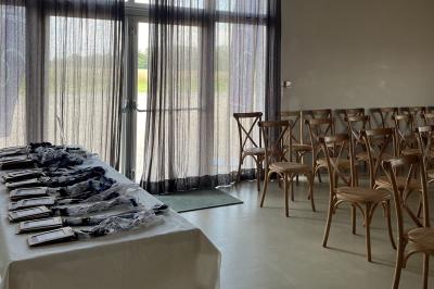 Des personnes participent à un atelier créatif dans une salle lumineuse, entourées de tables et de matériel artistique.