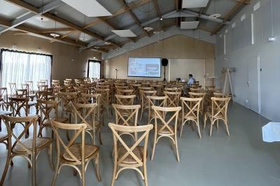 Des personnes participent à un atelier créatif dans une salle lumineuse, entourées de tables et de matériel artistique.