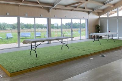 Des personnes participent à un atelier créatif dans une salle lumineuse, entourées de tables et de matériel artistique.