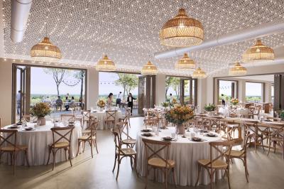 Un couple en tenue de mariage marche dans un champ verdoyant par une journée ensoleillée.