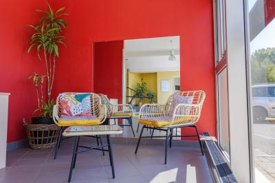 Deux chaises longues colorées devant une décoration murale représentant une plage avec un palmier.