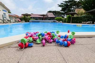 Deux chaises longues colorées devant une décoration murale représentant une plage avec un palmier.