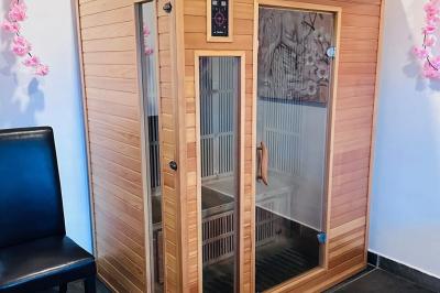 Piscine extérieure entourée de plantes fleuries, statues décoratives et vue dégagée sur un paysage tropical.