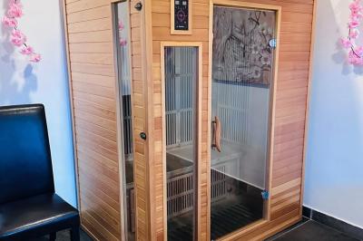 Piscine extérieure entourée de plantes en pot, avec vue sur un paysage tropical et un ciel dégagé.
