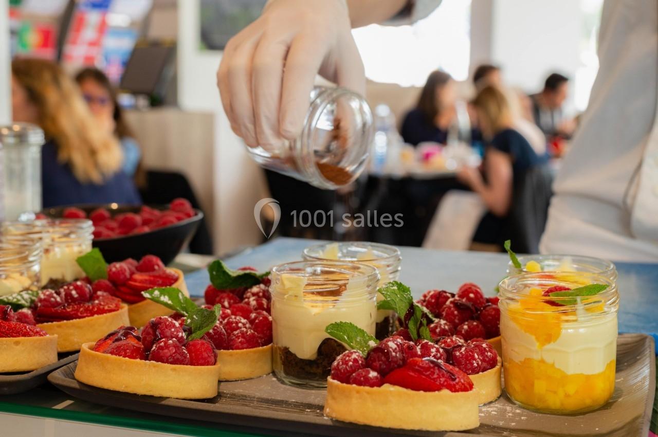 Desserts variés, dont des tartes aux fruits et verrines, servis sur un plateau dans un cadre de restauration.