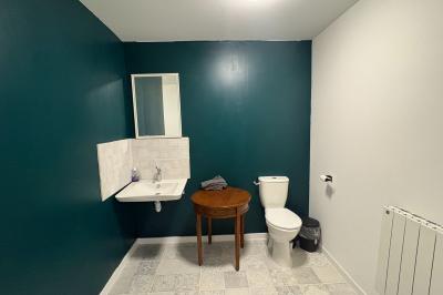 Intérieur d'une pièce avec grandes baies vitrées, murs en bois, un chauffage mobile et un conteneur bleu.