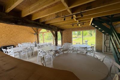 Cuisine ouverte avec plan de travail en bois, armoires vertes, éclairage au plafond et poutres apparentes.